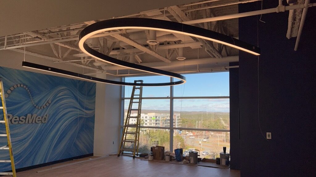 Curved LED light fixture installed by Bay Road Electrical in a commercial office fit-out