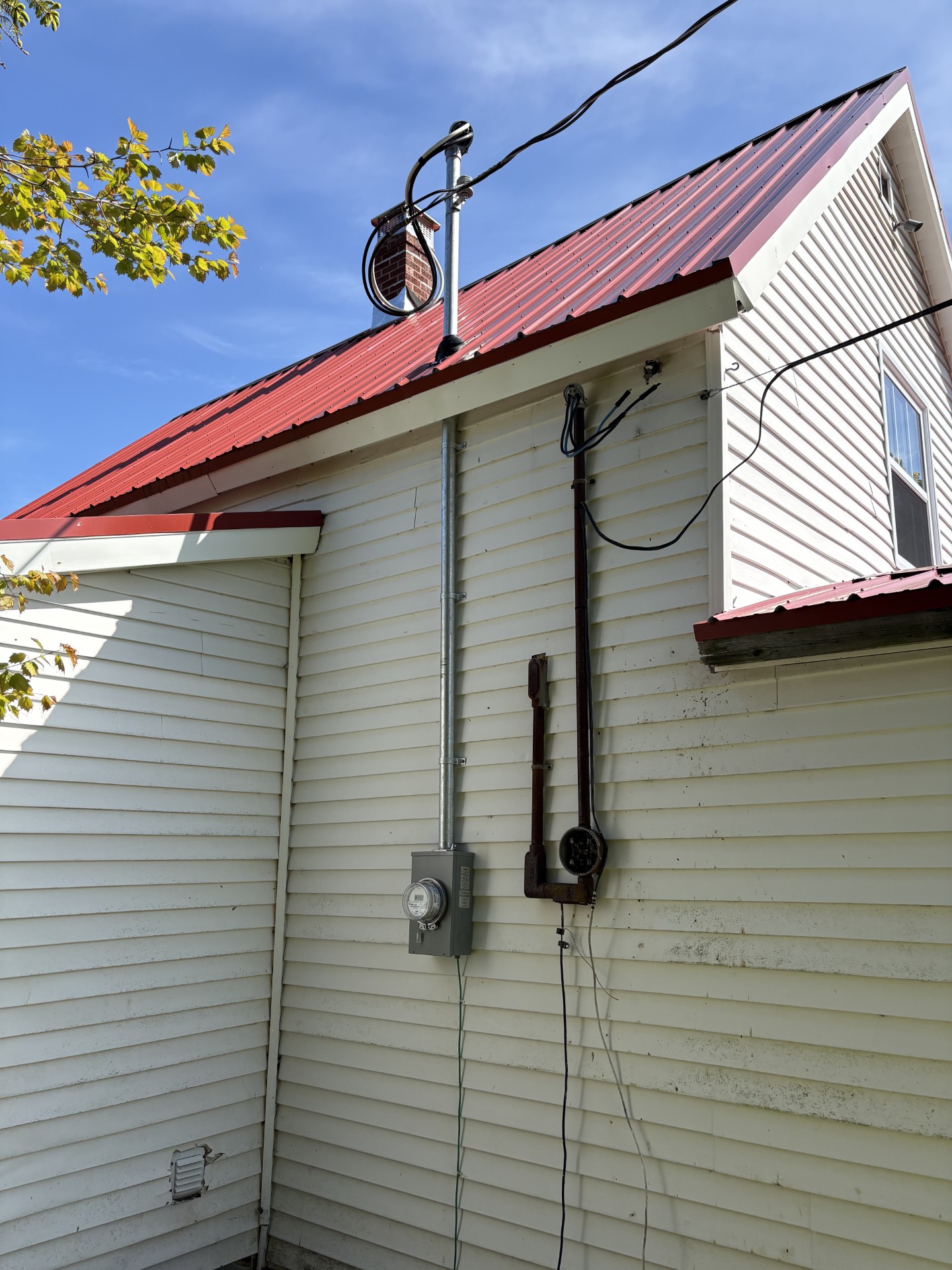 New electrical service and meter installed beside the old one on a residential exterior